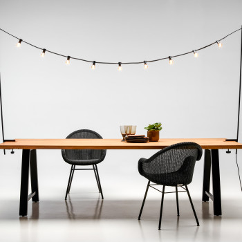 Vincent Sheppard Matteo eettafel met een bank en Light My Table-verlichting, vergezeld van Edgard eetkamerstoelen met een zwart stalen A-frame onderstel.